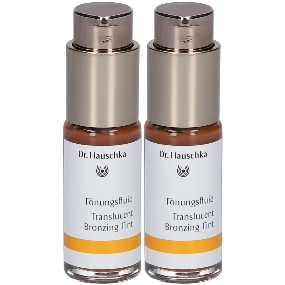 Zwei Flaschen Tönungsfluid. Aufschrift: Dr. Hauschka, Tönungsfluid, Translucent Bronzing Tint. Flaschen mit silberfarbenen Deckeln.