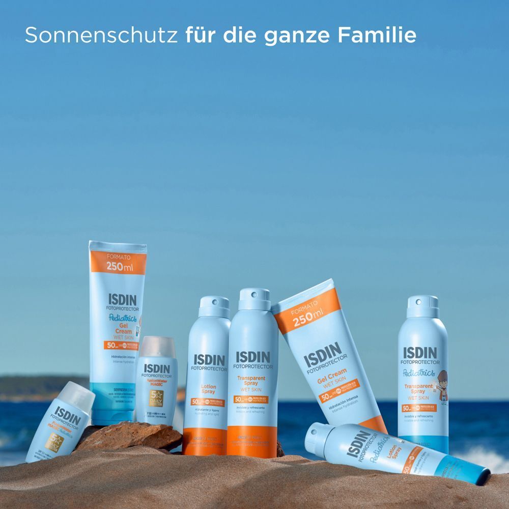 Verschiedene ISDIN Sonnenschutzprodukte auf Sand. Flaschen und Tuben in verschiedenen Größen. ISDIN-Logo sichtbar.