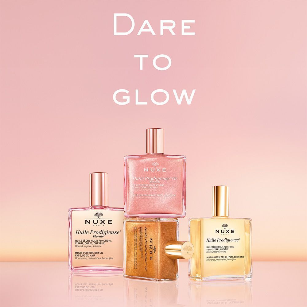 Drei Flakons mit Öl. Aufschrift: Nuxe Huile Prodigieuse® Or Florale. Quadratische Flakons mit goldenen Verschlüssen. Text: Dare to Glow.