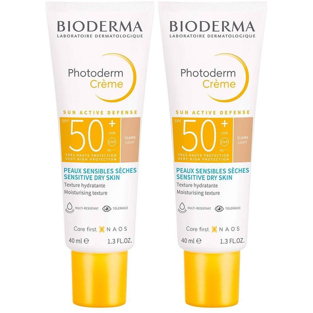 Zwei Tuben BIODERMA Photoderm Crème LSF 50+ hell getönt. Weiße Tuben mit gelben Akzenten. Aufdruck: SPF 50+, Textur hydratante, 40 ml.