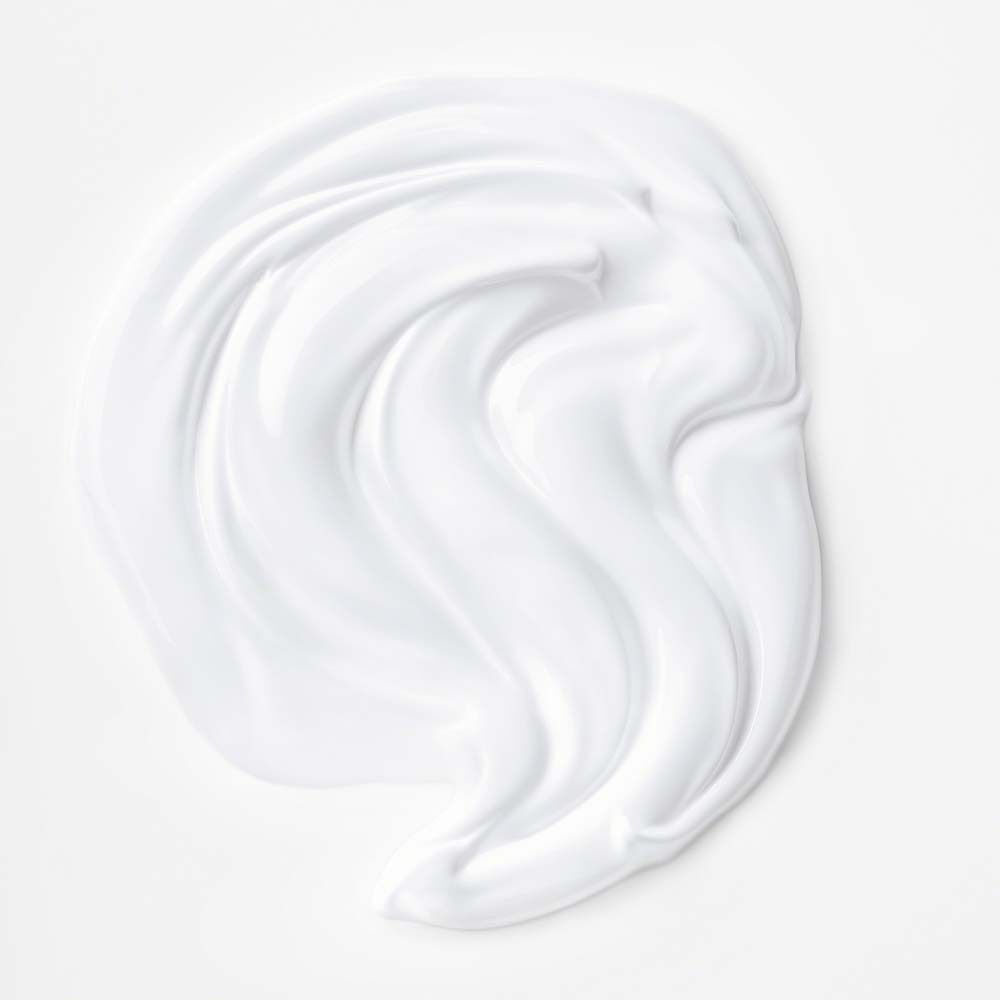 Weiße Creme-Textur in einer geschwungenen Form auf weißem Hintergrund.