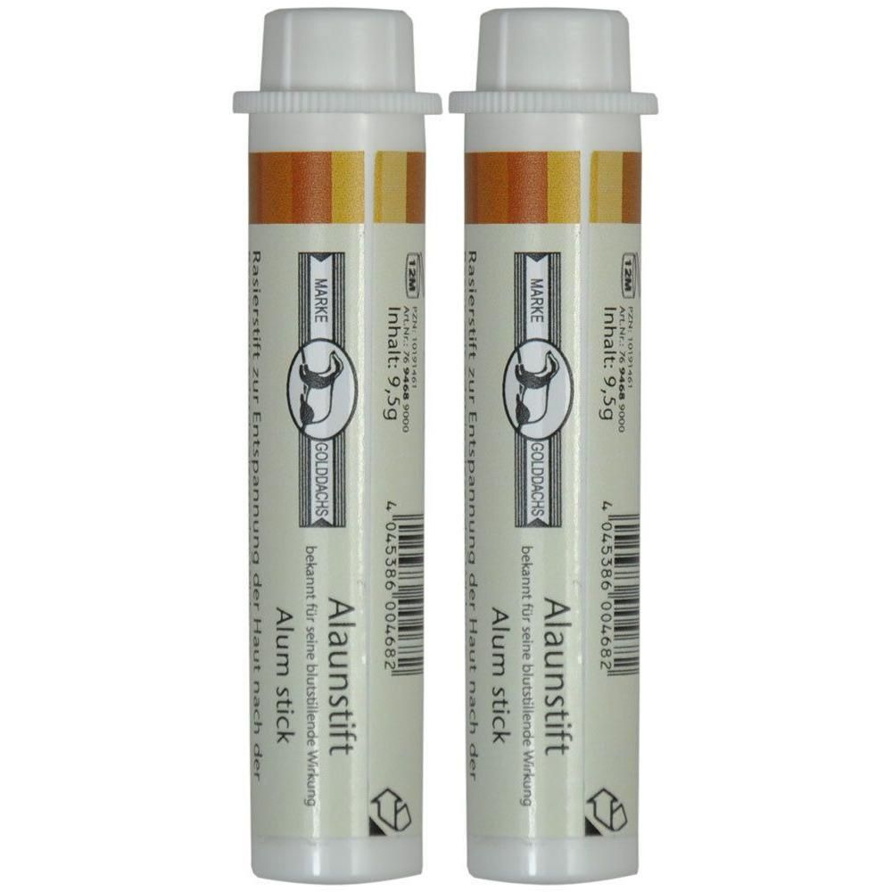 Zwei zylindrische Alaunstifte mit weißen Kappen. Aufschrift: GOLDDACHS Alaunstift, Inhalt 9,5g. Bekannt für blutstillende Wirkung.