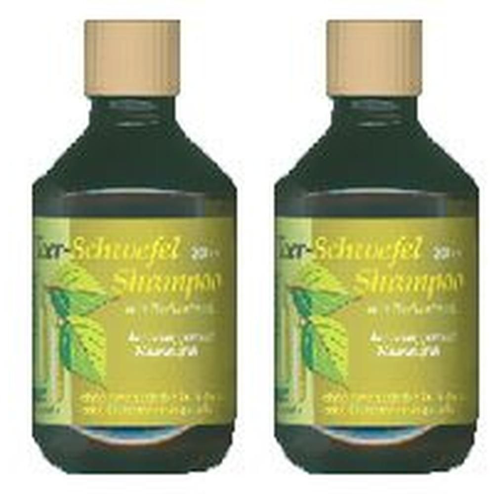 Zwei Flaschen Shampoo mit braunen Deckeln. Etiketten mit Text und Blättern. Dunkelgrüne Flaschen.