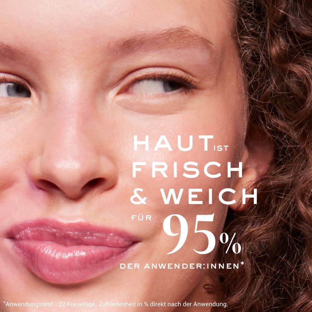 Nahaufnahme eines Gesichts mit Text: HAUT IST FRISCH & WEICH FÜR 95% DER ANWENDER:INNEN. Text darunter: Anwendungstest - 22 Freiwillige.