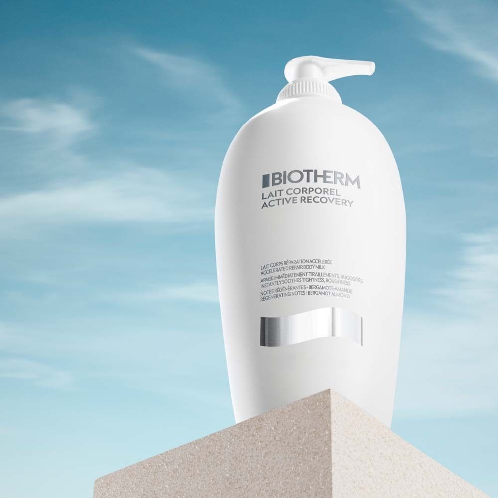 Weiße Flasche Biotherm Lait Corporel Active Recovery Bodylotion auf Podest. Text auf Etikett.