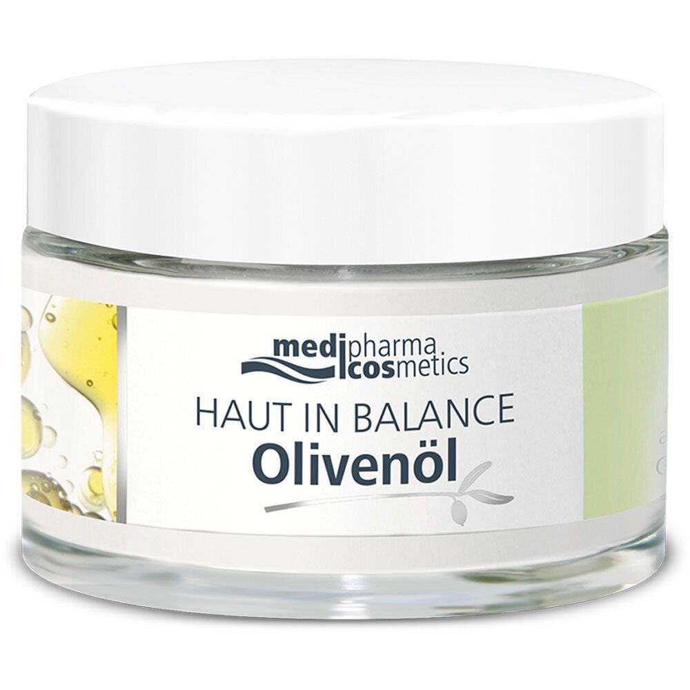 Glasbehälter mit weißem Deckel. Aufschrift: medipharma cosmetics, Haut in Balance Olivenöl. Etikett mit Olivenöl-Illustration und Blättern.