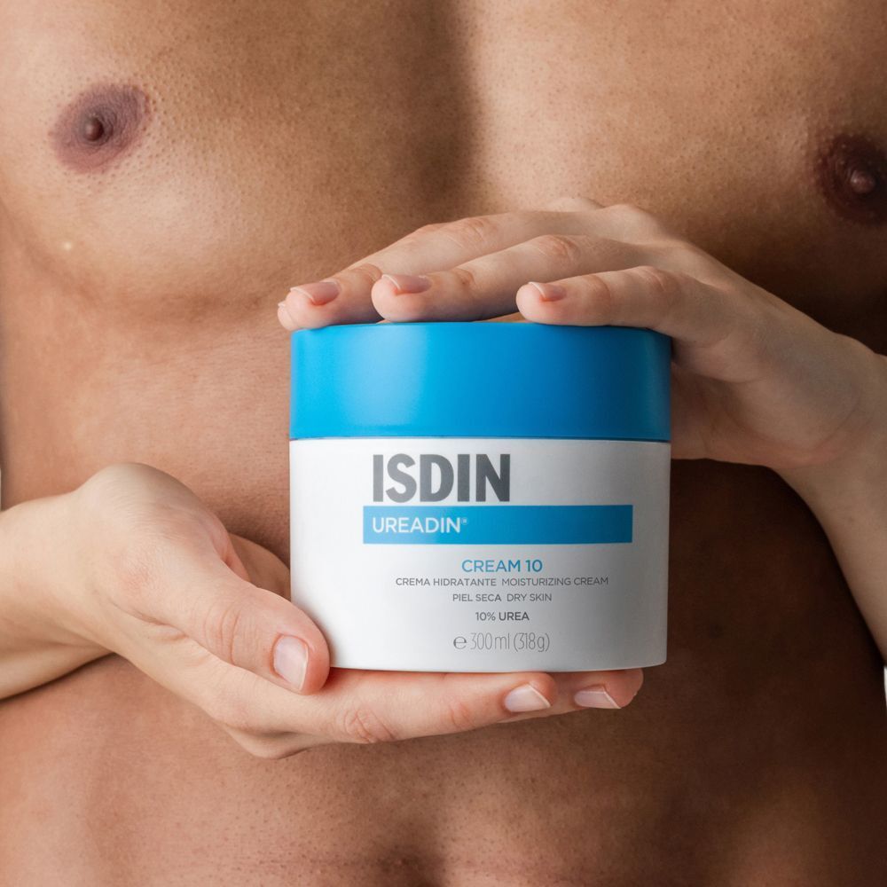 Ein weißer Cremetiegel mit blauem Deckel. Hände halten den Tiegel. Aufschrift: ISDIN Ureadin Cream 10.