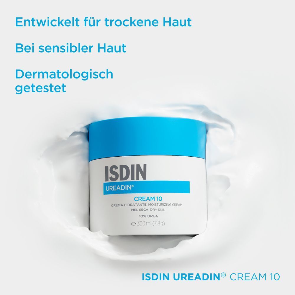 Weißer Cremetiegel mit blauem Deckel in weißer Flüssigkeit. Aufschrift: ISDIN Ureadin Cream 10.
