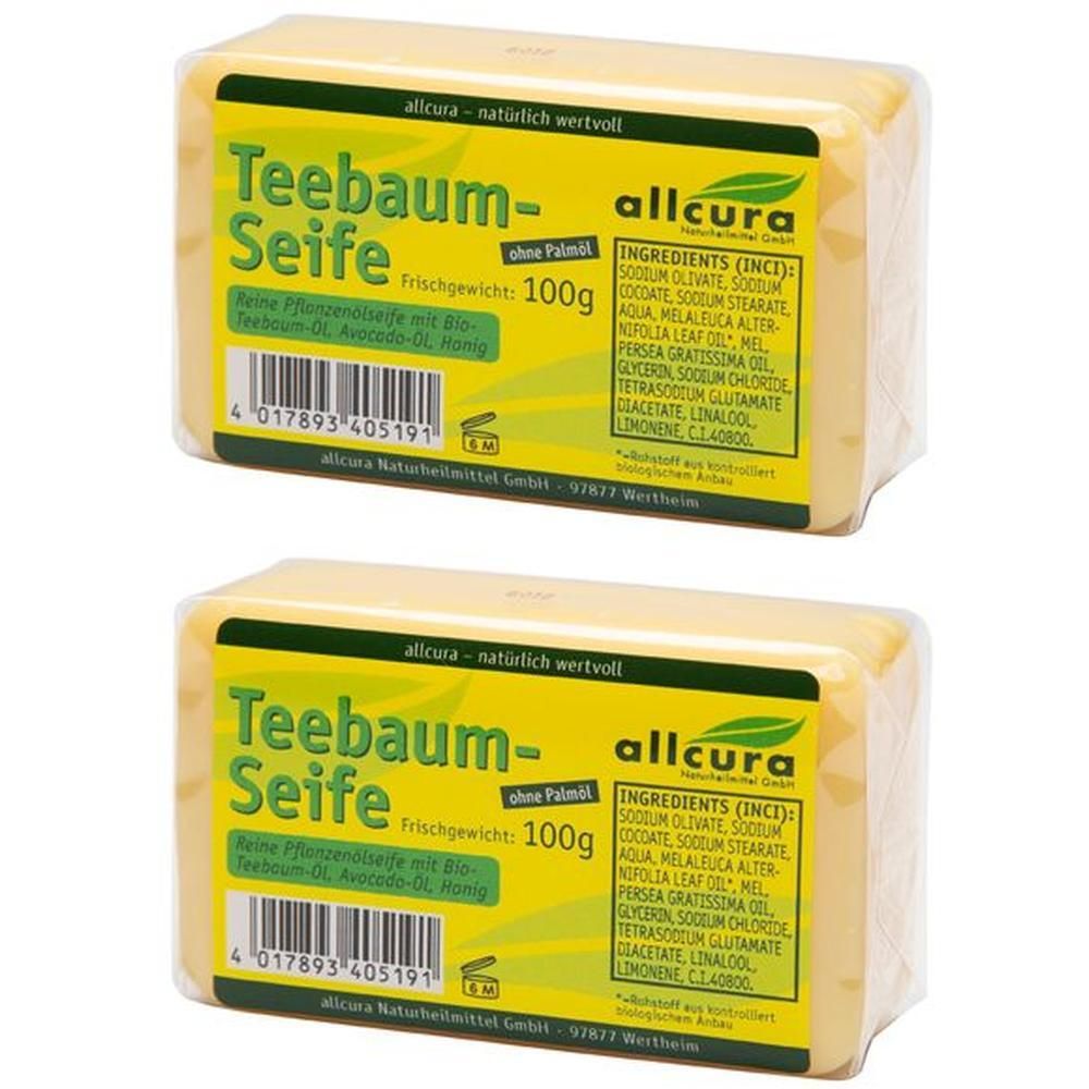 Zwei Seifenstücke in Folie verpackt. Gelbe Seife mit grünem Etikett. Aufschrift: Teebaum-Seife, 100g, Inhaltsstoffe.