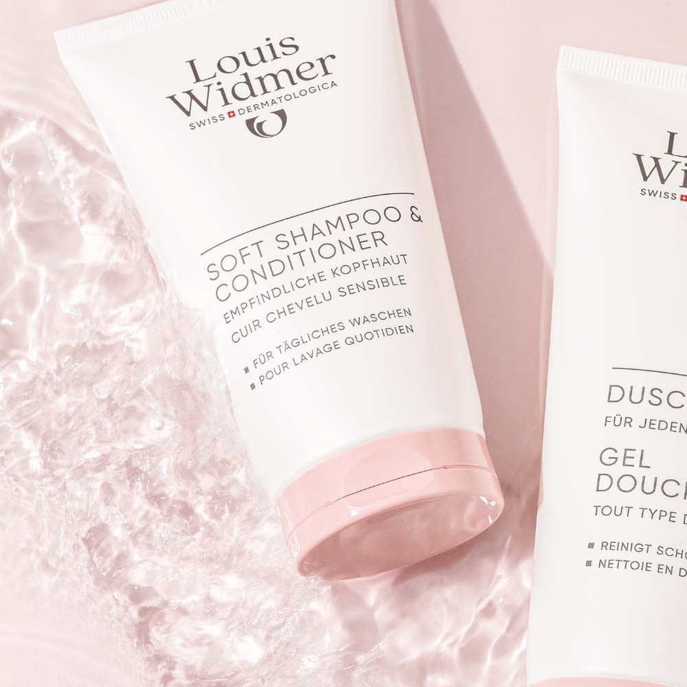 Zwei Tuben Louis Widmer Soft Shampoo & Conditioner, teilweise im Wasser. Weiße Tuben mit rosa Verschlusskappe. Produktname und Logo.