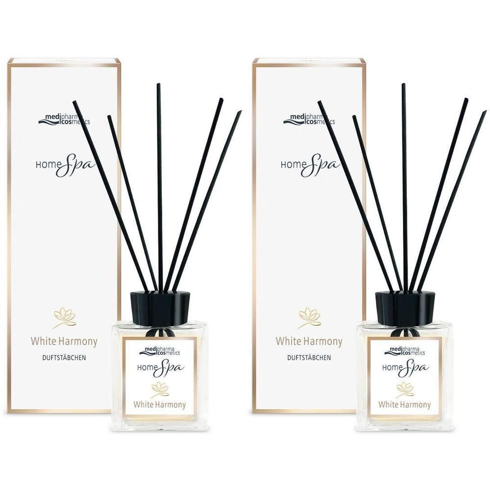 Zwei Raumduft-Sets mit quadratischen Glasflakons, schwarzen Stäbchen und weißer Verpackung. Aufschrift: Home Spa White Harmony.