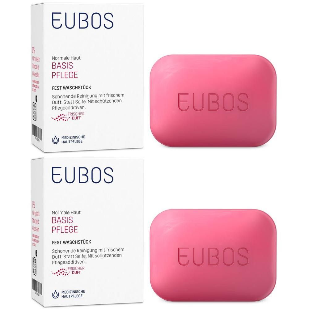Zwei Packungen und zwei rosa Seifenstücke. Auf den Packungen steht "EUBOS BASIS PFLEGE". Auf den Seifen steht "EUBOS".