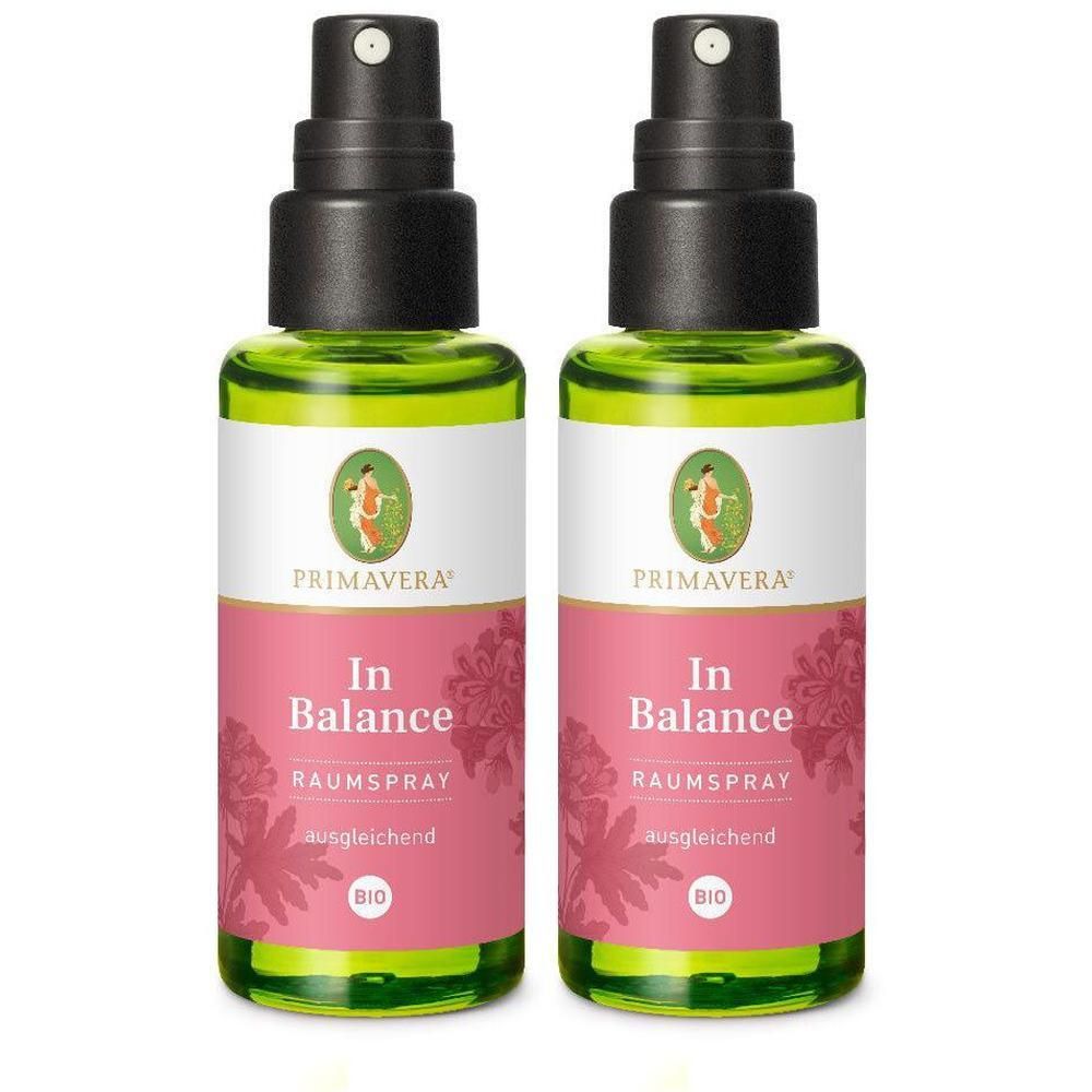 Zwei grüne Glasflaschen mit schwarzem Sprühkopf. Aufschrift: PRIMAVERA, In Balance Raumspray, BIO. Rosa Etikett mit floralem Muster.