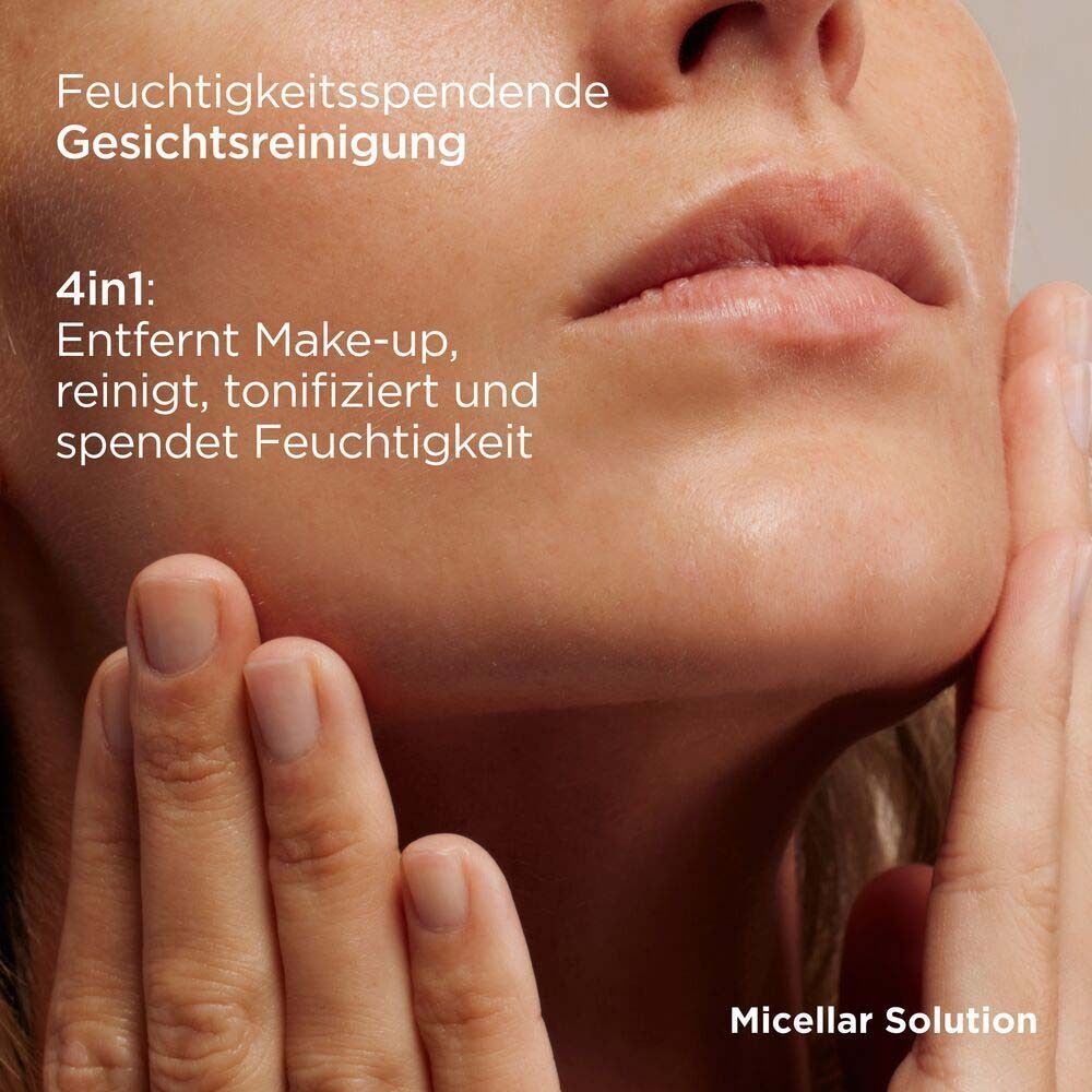 Nahaufnahme einer Frau, die ihr Gesicht berührt. Text: Feuchtigkeitsspendende Gesichtsreinigung. 4in1: Entfernt Make-up, reinigt, tonifiziert und spendet Feuchtigkeit.