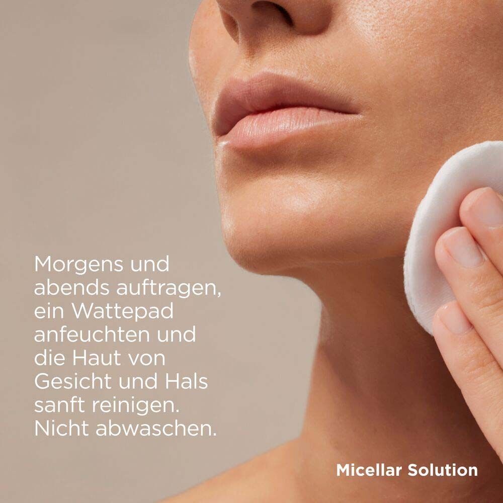 Nahaufnahme einer Frau, die ihr Gesicht mit einem Wattepad reinigt. Text: Morgens und abends auftragen, Wattepad anfeuchten und Haut reinigen.