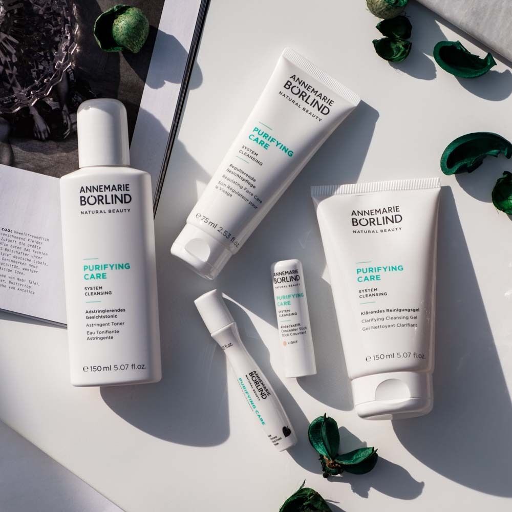 Fünf weiße Tuben und Flaschen der Annemarie Börlind Purifying Care Serie, darunter ein Toner und ein Reinigungsgel.