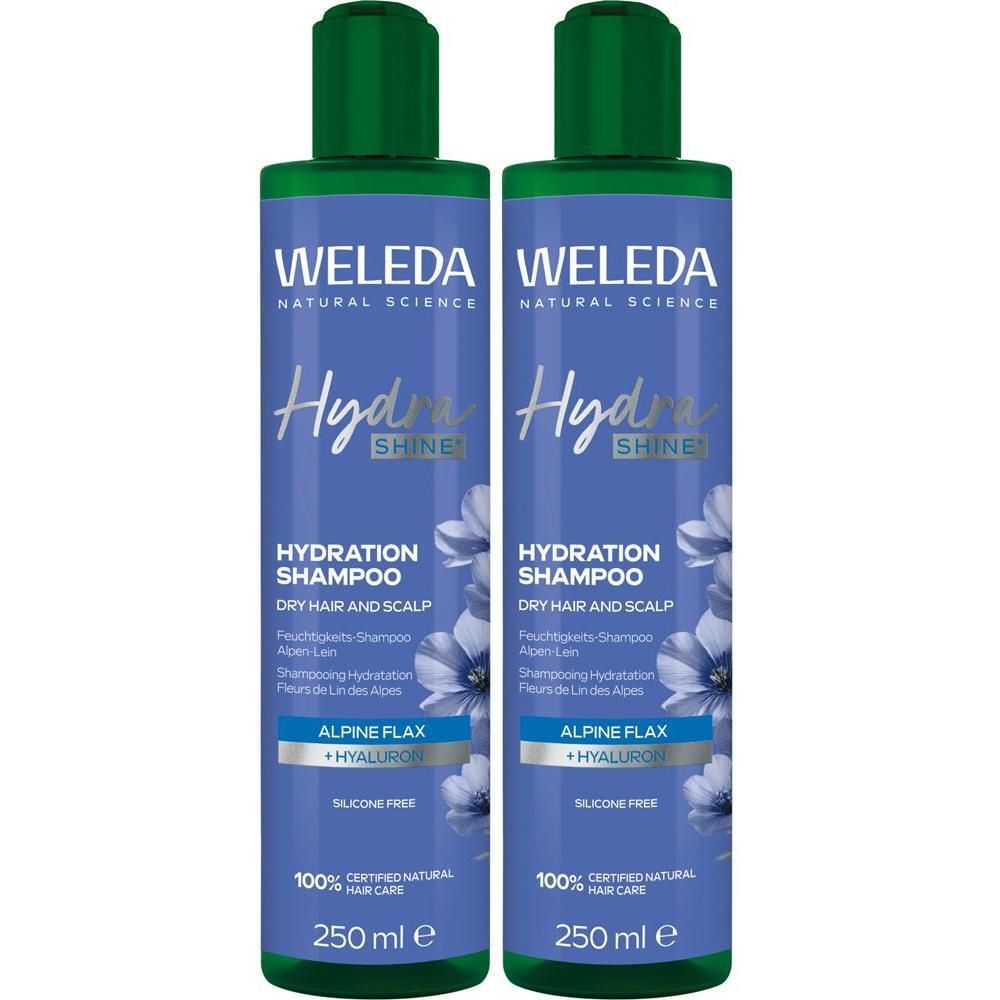 Zwei Flaschen Weleda Hydra Shine Shampoo. Grün-weiße Etiketten, grüne Kappen. Text: Hydra Shine, Hydration Shampoo, Alpine Flax + Hyaluron.