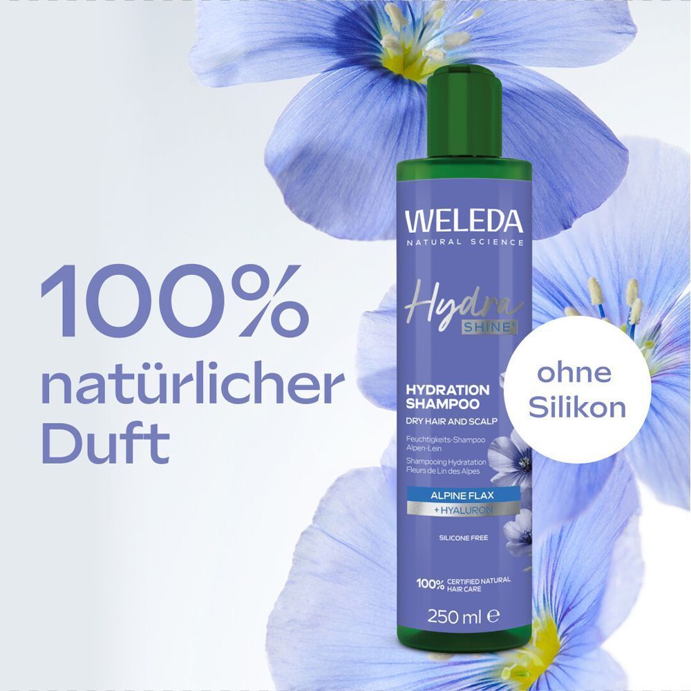 Weleda Hydra Shine Shampoo-Flasche. Grün-weiße Etikett, grüne Kappe. Text: 100% natürlicher Duft, ohne Silikon. Hintergrund: blaue Blumen.