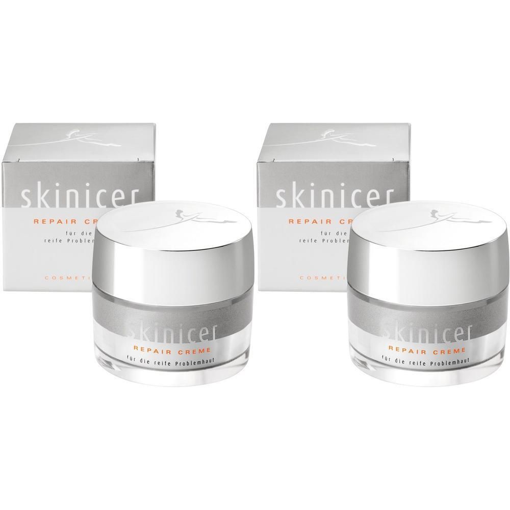 Zwei Tiegel skinicer® Repair Creme mit Umverpackung. Cremetiegel mit silberfarbenem Rand und Deckel, Schriftzug skinicer® Repair Creme.