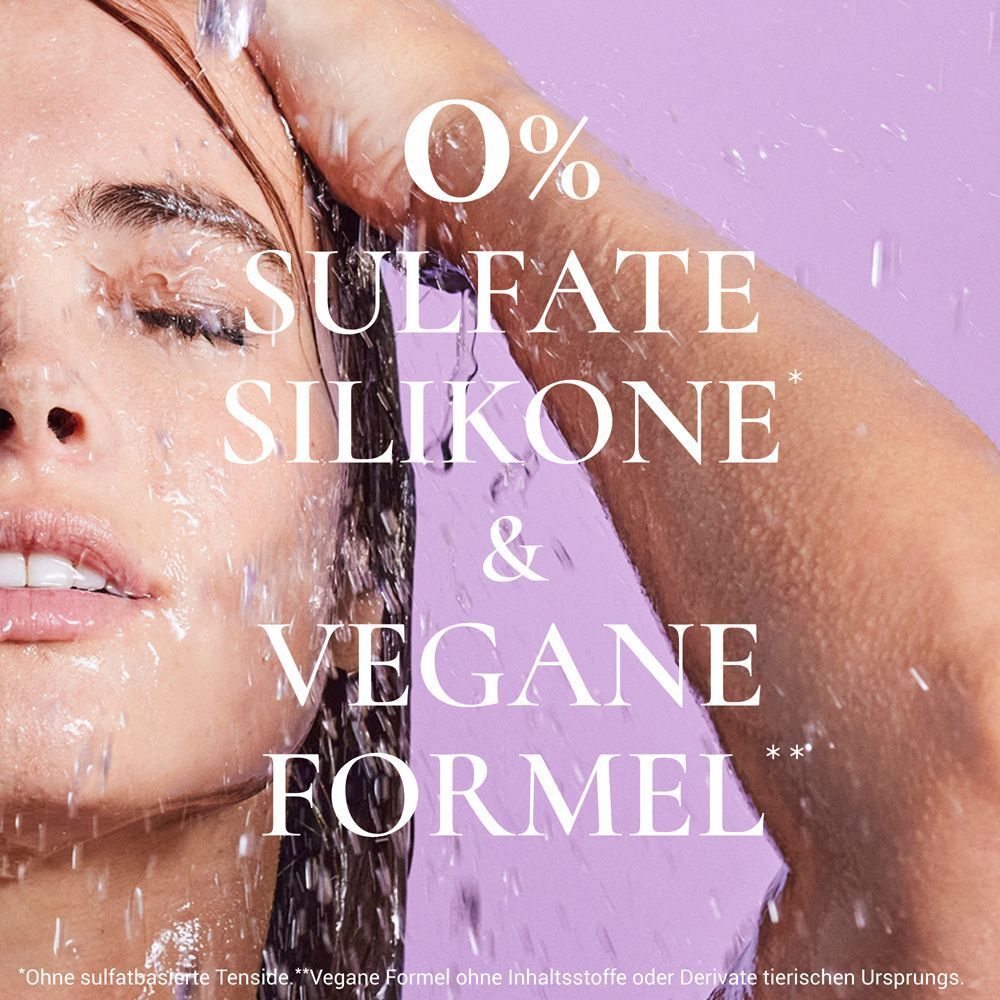 Nahaufnahme einer Frau, die Wasser über ihr Haar gießt. Text: 0% Sulfate, Silikone & Vegane Formel.