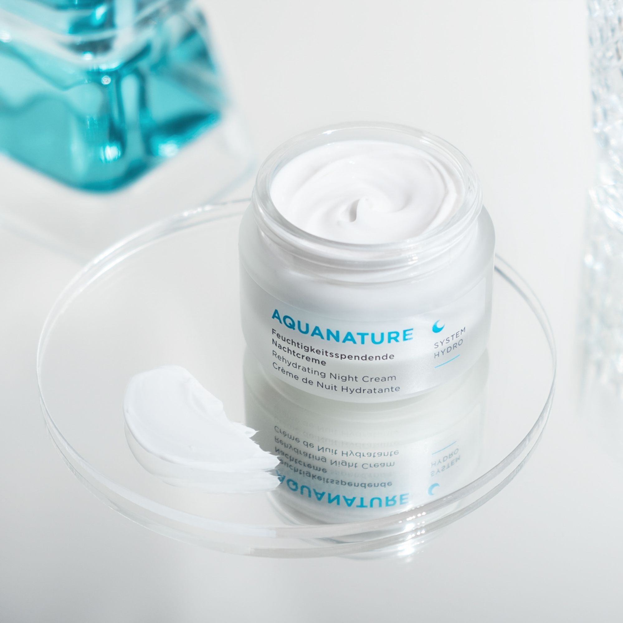 Ein offener Tiegel mit ANNEMARIE BÖRLIND AQUANATURE Nachtcreme und einer Probe daneben.