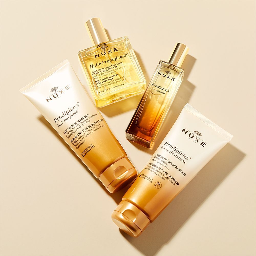 Verschiedene Produkte: Körperlotion, Duschgel und Öle. Goldfarbene Verpackung. Produktnamen und Logos sichtbar.