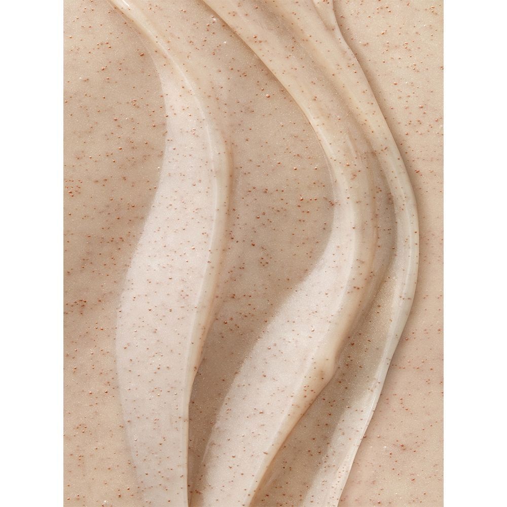 Nahaufnahme von Creme mit kleinen braunen Partikeln. Wellenförmige Textur. Cremefarbene Creme.