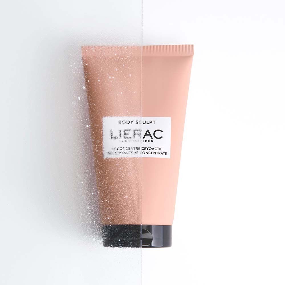 Tube LIERAC Body Sculpt Kryoaktives Konzentrat. Rosa Tube mit schwarzem Verschluss und weißem Etikett. Teilweise mit weißen Partikeln bedeckt.