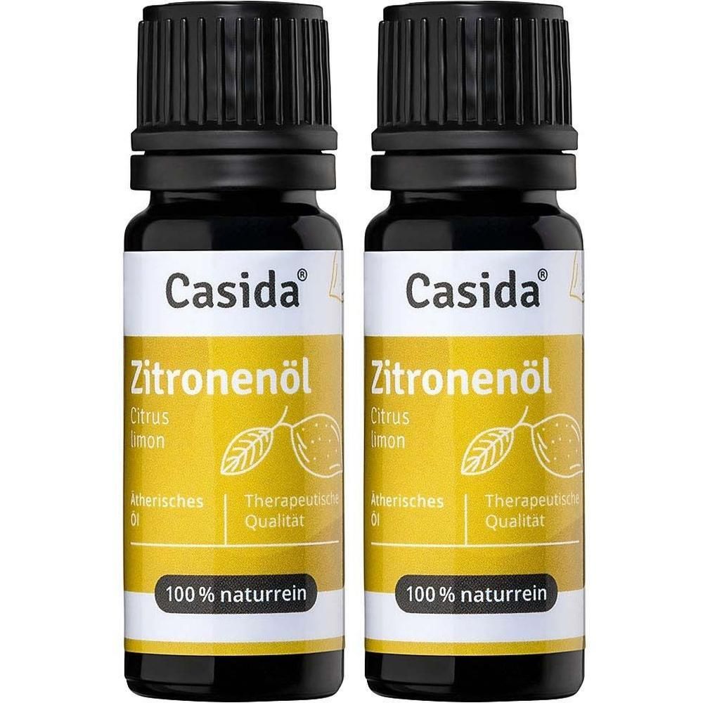 Zwei Flaschen Casida Zitronenöl. Schwarze Kappe, gelbes Etikett mit Produktnamen und Illustrationen. 100% naturrein.
