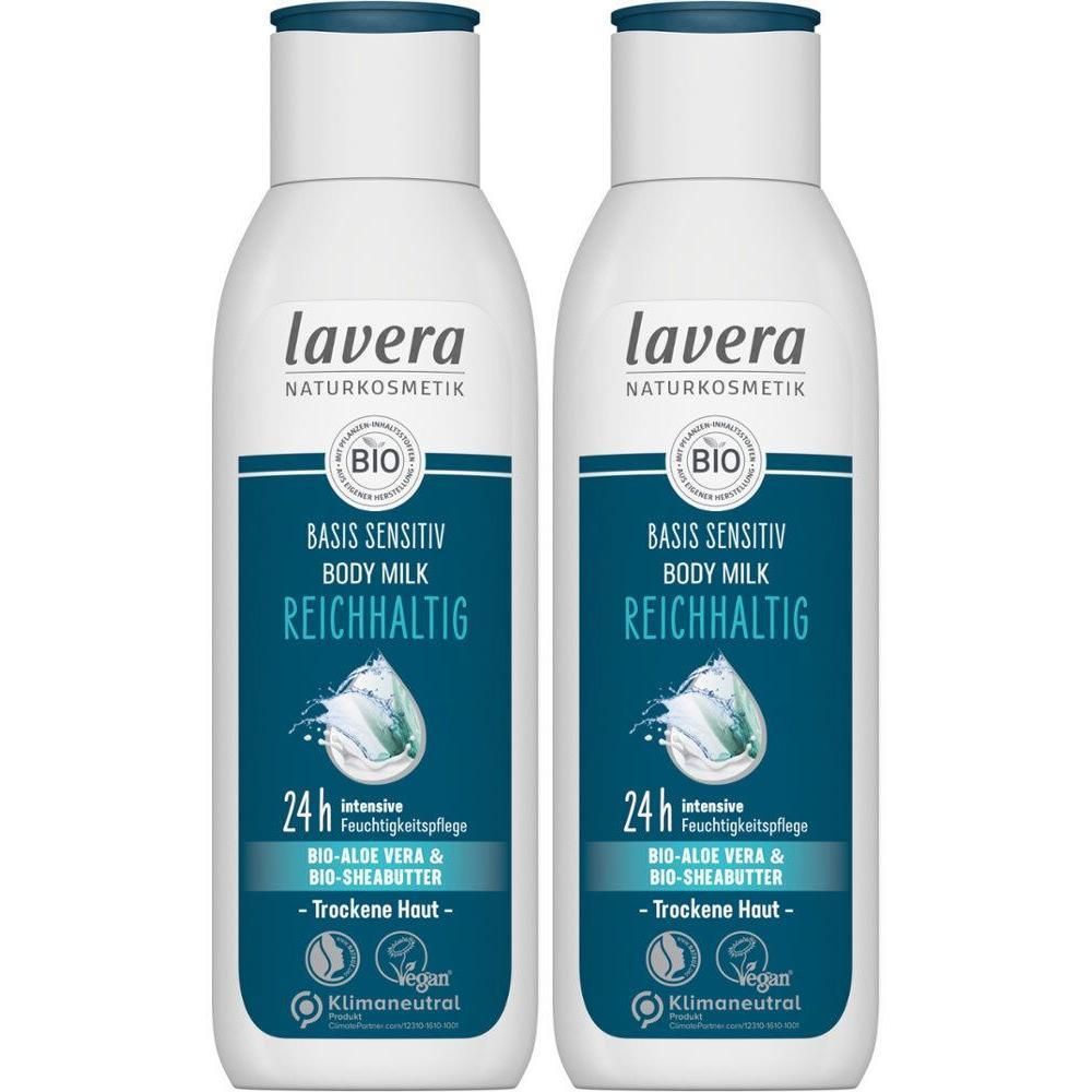 Zwei Flaschen Body Milk. Weißes Etikett mit blauem Logo und Text. "Basis Sensitiv Body Milk Reichhaltig". Vegan-Siegel.