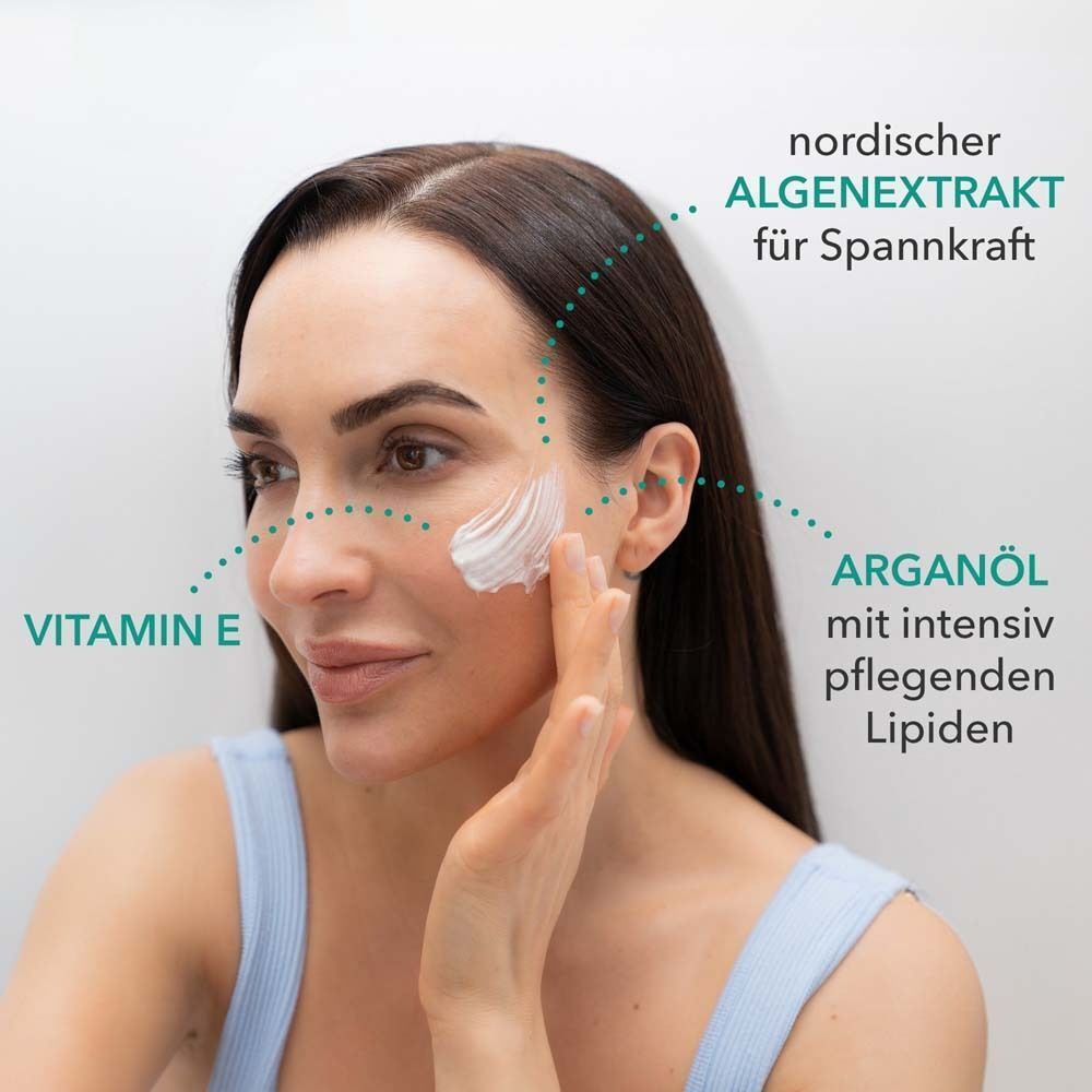 Frau trägt Maske auf. Text: Vitamin E, Arganöl mit Lipiden, nordischer Algenextrakt für Spannkraft.