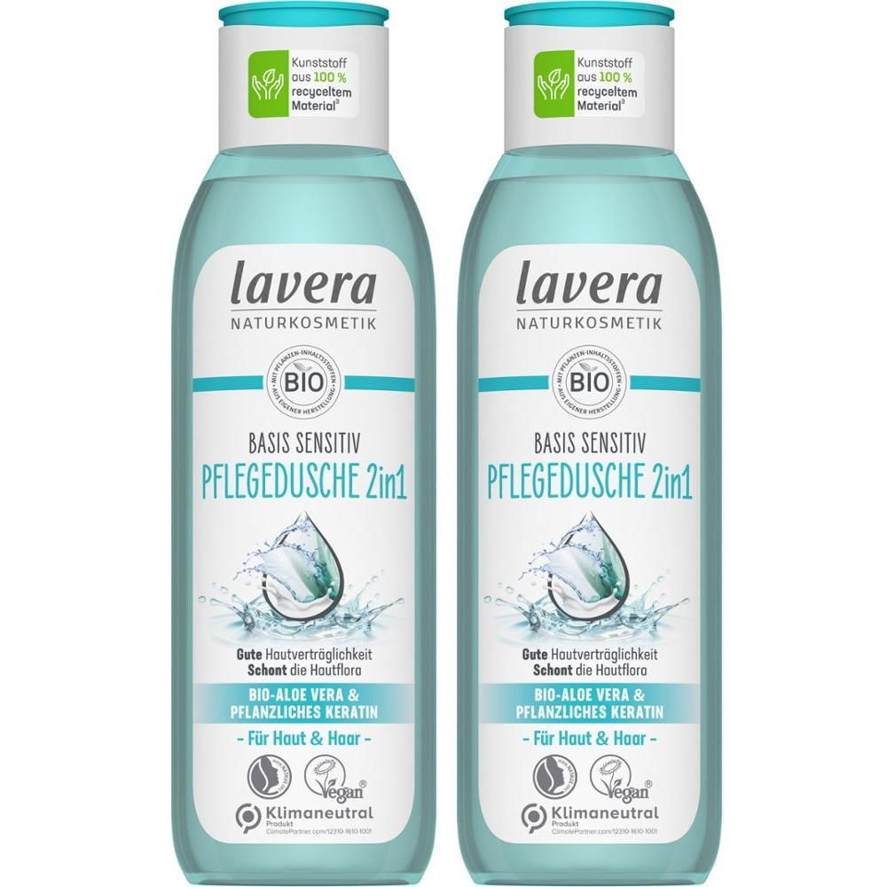 Zwei Flaschen lavera BASIS SENSITIV Pflegedusche 2in1. Hellblaue Flüssigkeit, weißes Etikett, grüne Blätter-Logo, vegan.