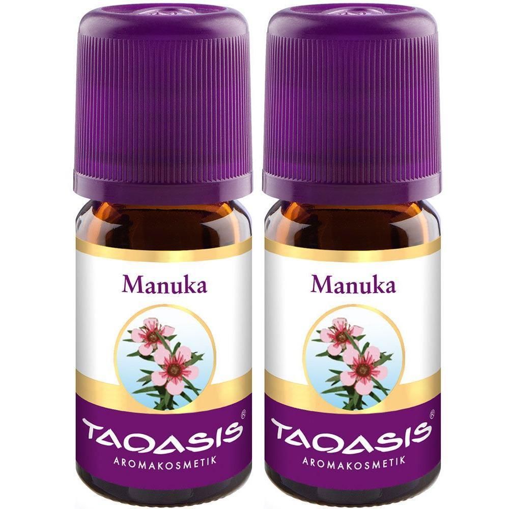 Zwei kleine Glasflaschen mit lila Deckeln. Auf den Etiketten steht "Manuka" und "TAOASIS Aromakosmetik".