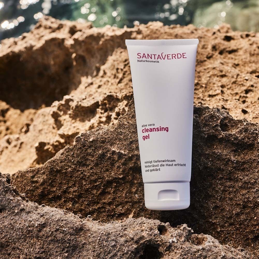 Weiße Tube mit SANTAVERDE-Logo und Text. Aufschrift: Aloe vera cleansing gel. Liegt auf einem Stein. Reinigt tiefenwirksam und klärt.