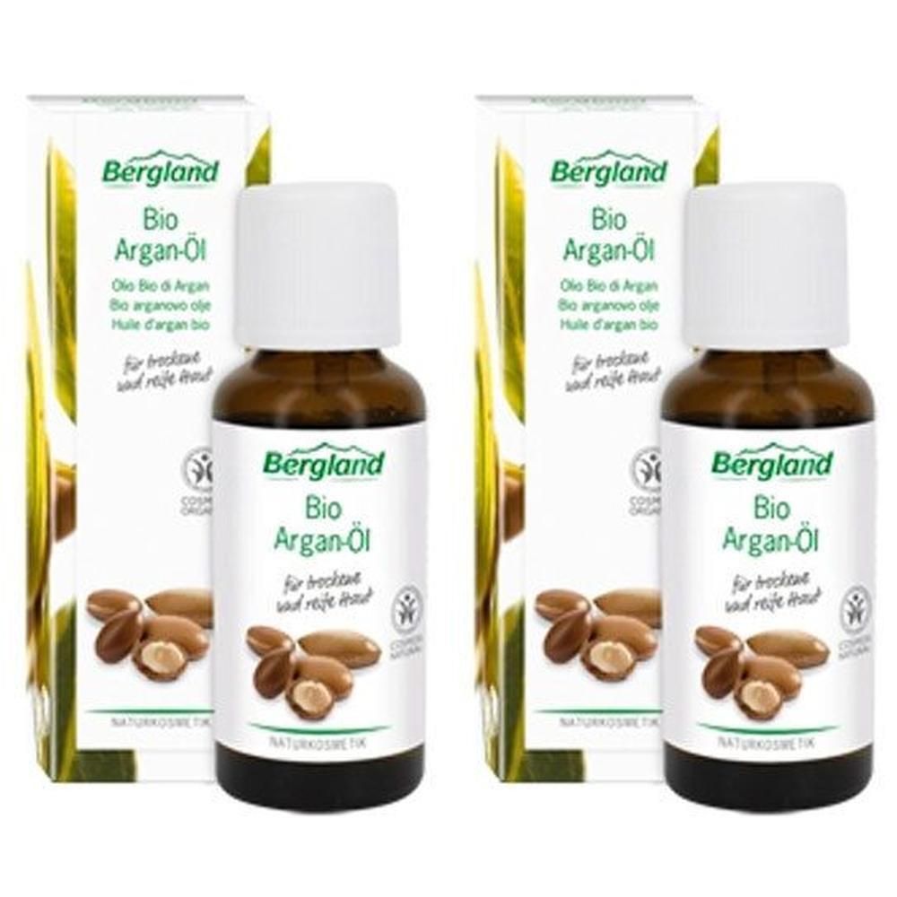 Zwei Flaschen mit weißem Deckel und Etikett. Auf dem Etikett steht "Bergland Bio Argan-Öl". Daneben zwei Kartons mit gleichem Design.