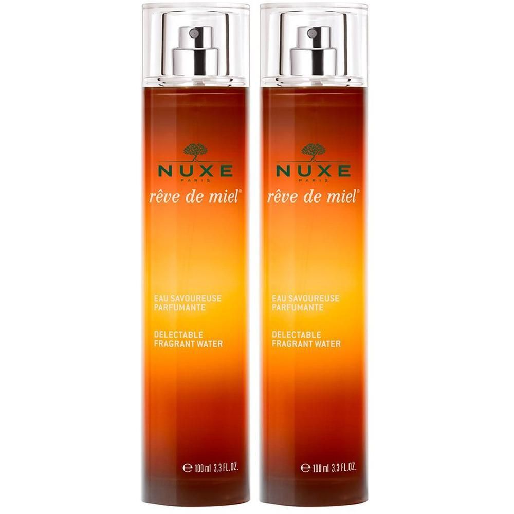 Zwei Flakons mit Sprühkopf. Aufschrift: NUXE Reve de Miel. Delectable Fragrant Water. Farbverlauf von bernsteinfarben nach transparent.