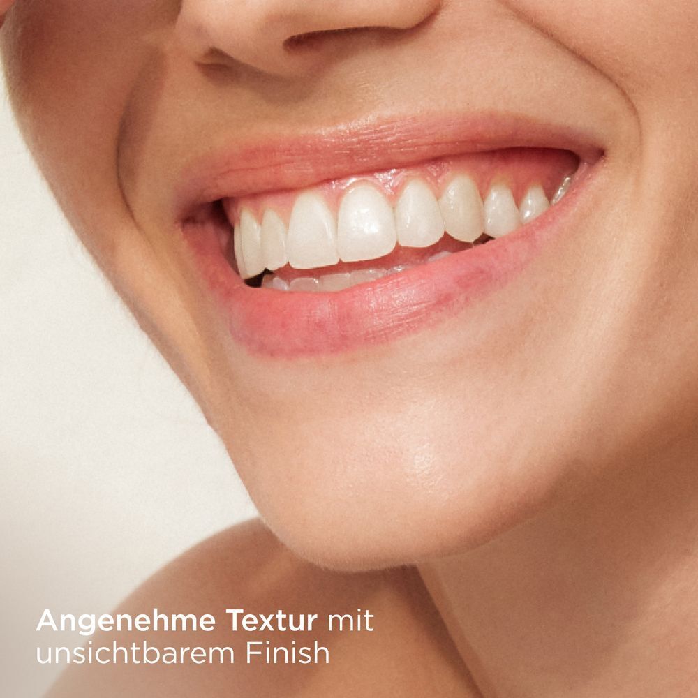 Nahaufnahme eines lächelnden Mundes. Text: Angenehme Textur mit unsichtbarem Finish.