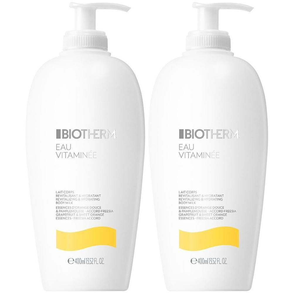 Zwei weiße Flaschen BIOTHERM Eau Vitaminée Bodymilk mit Pumpverschluss. Gelbes Etikett. Text: Lait Corps, Revitalisant & Hydratant.