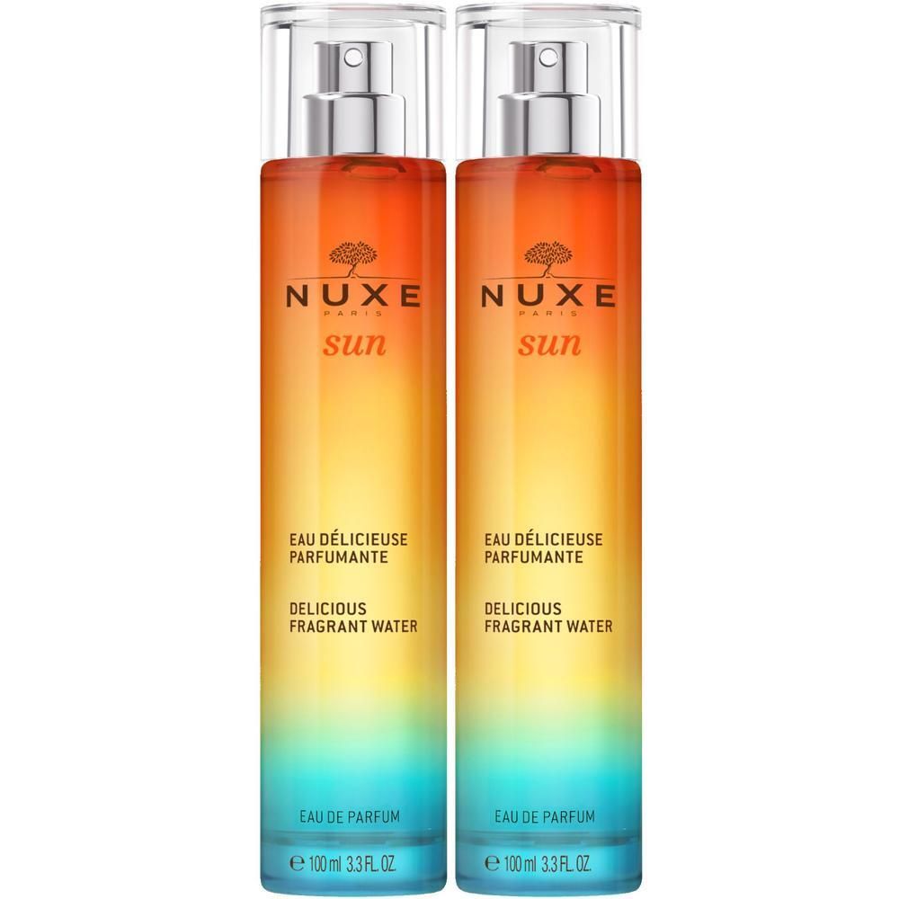 Zwei Flakons mit Sprühkopf. Farbverlauf von blau nach orange. Text: NUXE Sun, Eau Délicieuse Parfumante, Delicious Fragrant Water.