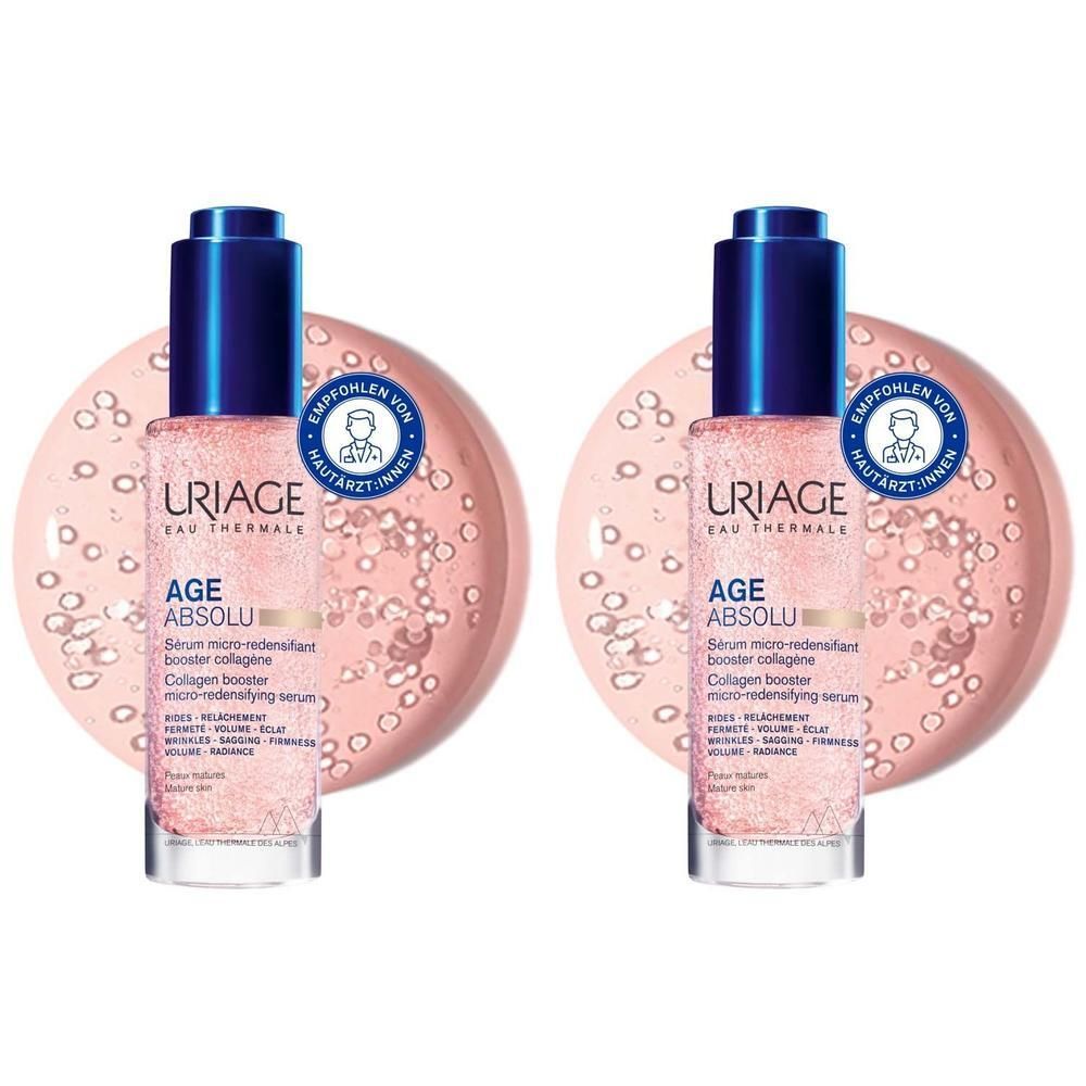 Zwei Flaschen Serum mit blauen Kappen und rosa Flüssigkeit. Aufkleber mit Text und einem Logo. Im Hintergrund rosa Kreise mit kleinen Kugeln.