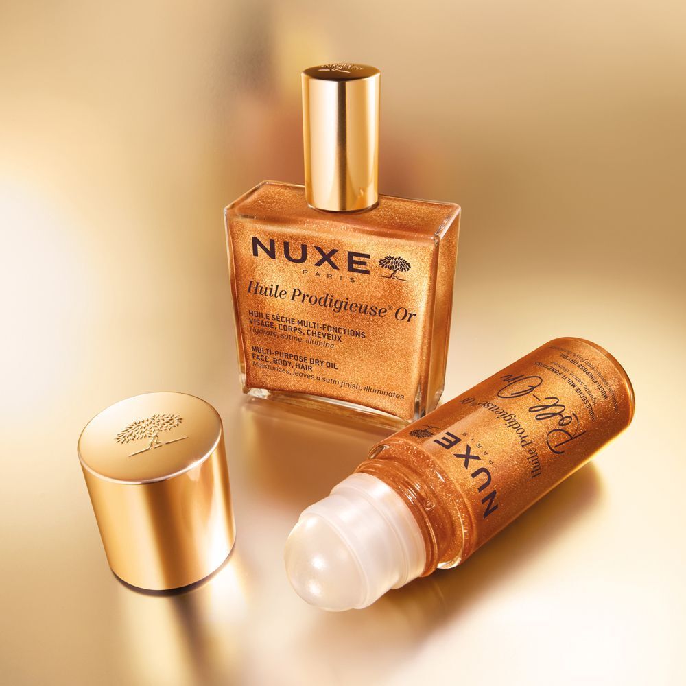 Goldfarbene Flasche und Roll-on-Flasche. Aufschrift: NUXE Paris, Huile Prodigieuse Or. Deckel daneben.