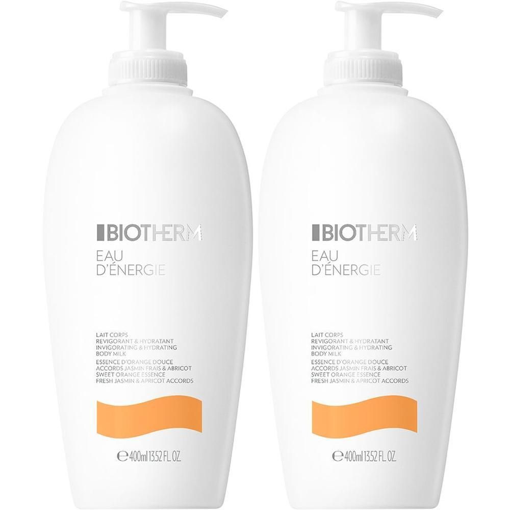 Zwei weiße Flaschen BIOTHERM Eau d'Energie Body Milk mit Pumpaufsatz. Orangefarbene Akzente und Produktinformationen auf den Etiketten.