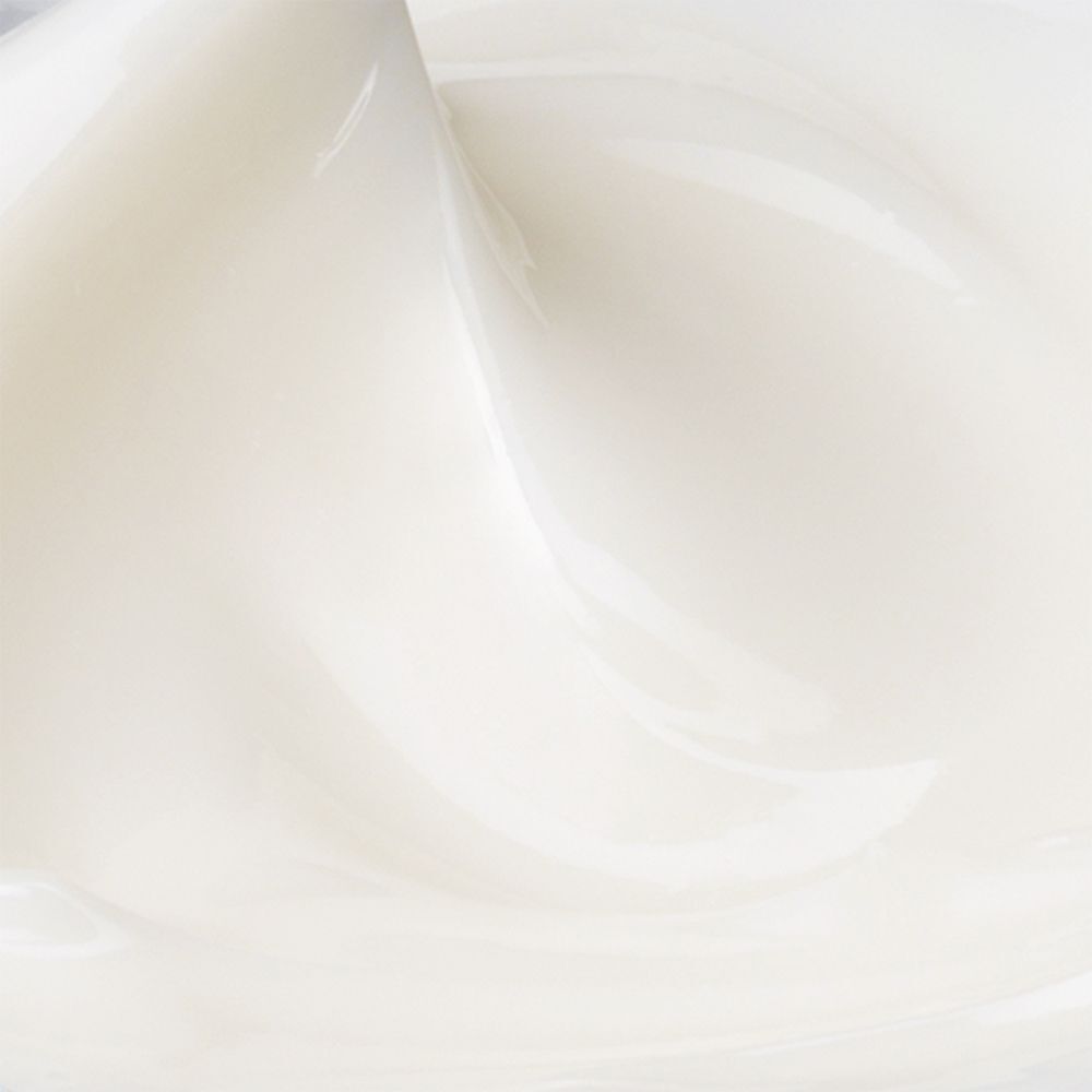 Nahaufnahme einer weißen Creme. Die Textur ist glatt und cremig.