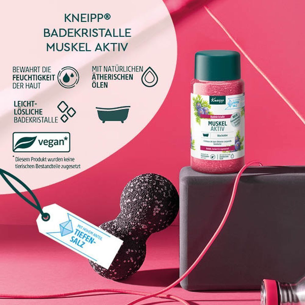 KNEIPP Badekristalle Muskel Aktiv Flasche neben Sportzubehör. Produkt mit grüner Kappe, rosa Kristallen und Blaubeer-Motiv.