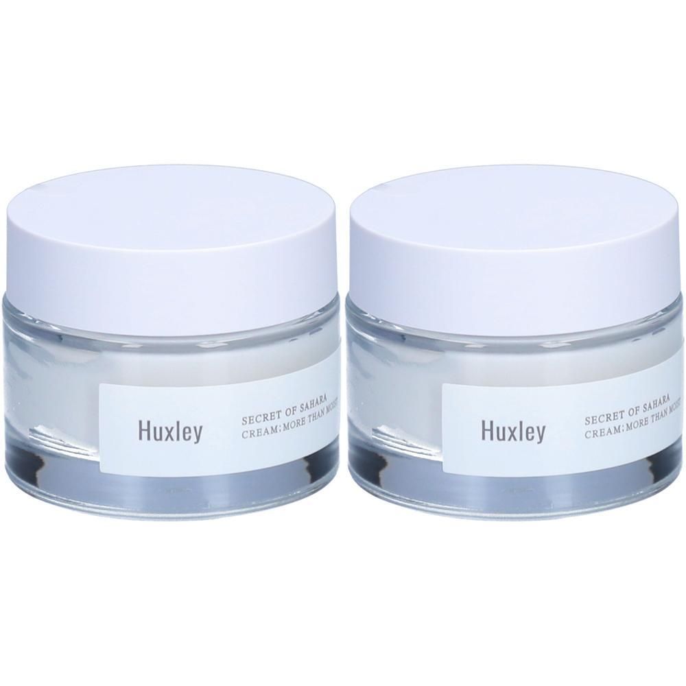 Zwei Cremetiegel mit weißen Deckeln. Auf den Etiketten steht "Huxley" und "SECRET OF SAHARA CREAM MORE THAN MOIST".