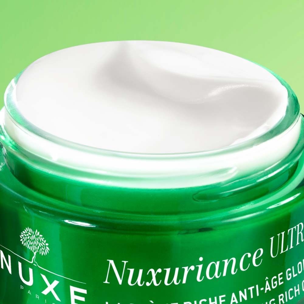 Nahaufnahme eines grünen Creme-Tiegels mit weißer Creme. Aufschrift: NUXE, Nuxuriance Ultra, Anti-Aging.