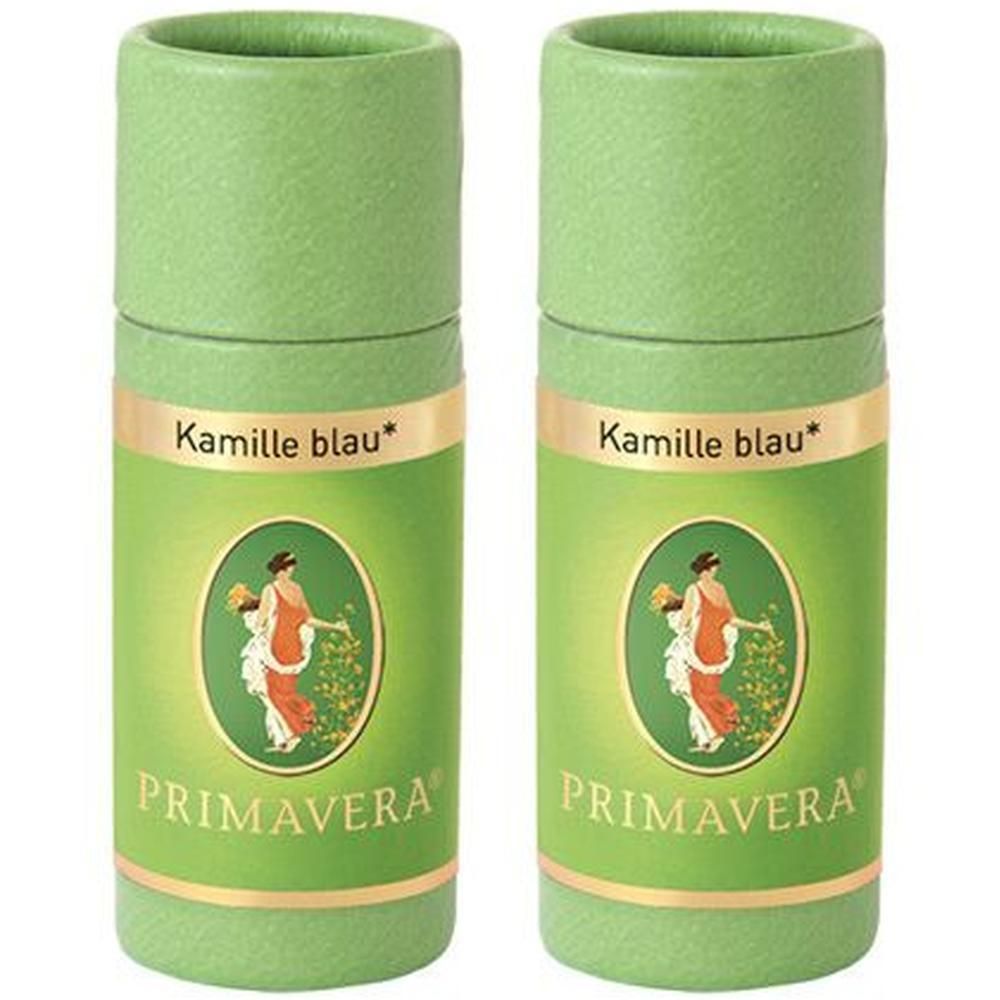 Zwei grüne zylindrische Behälter. Aufschrift: Kamille blau*. Darunter ein ovales Bild mit einer Frau. Darunter: PRIMAVERA®.