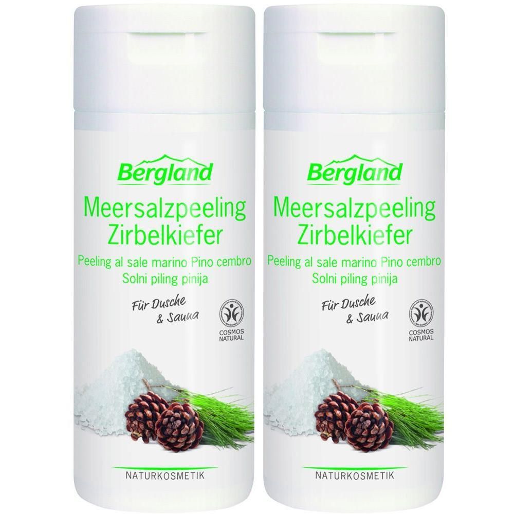 Zwei weiße Flaschen mit grünem Etikett. Aufschrift: Bergland Meersalzpeeling Zirbelkiefer. Mit Abbildung von Salz, Zapfen und Zweigen. Naturkosmetik.