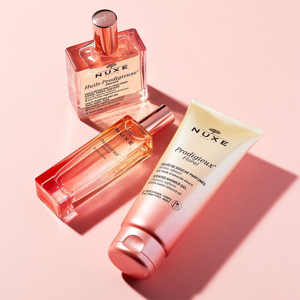 Drei NUXE Produkte: Prodigieux Floral Parfum Spray, Huile Prodigieuse und Gelée de Douche Parfumée. Rosa und goldfarbene Verpackungen.