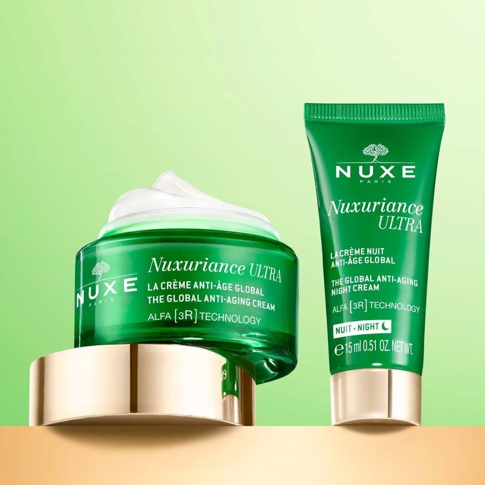 Grünes Creme-Glas und Tube NUXE Nuxuriance Ultra. Creme auf dem Glas. Goldfarbene Deckel. Aufschrift: La Crème Anti-Âge Global.